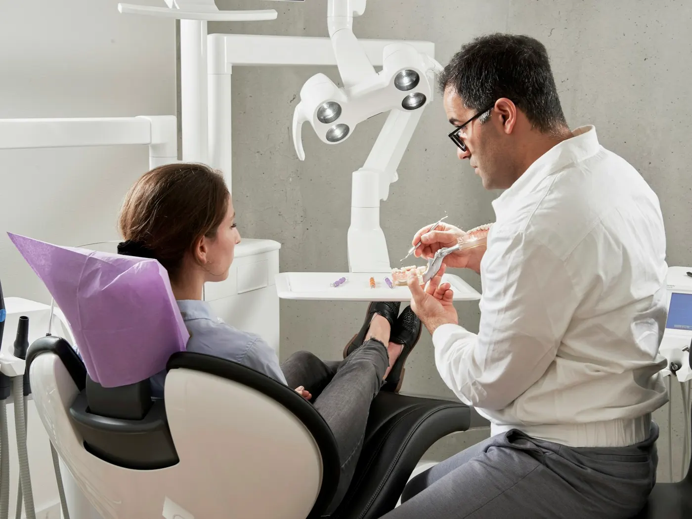 Dentista conversando com paciente na cadeira